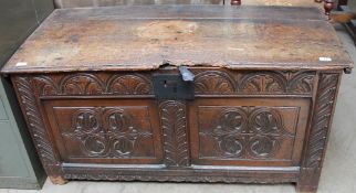An 18th century coffer with carved front and sides on stiles