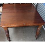 An Edwardian extending table on fluted legs and casters