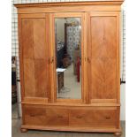 An Edwardian oak triple wardrobe with a moulded cornice,