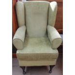 An upholstered wing back elbow chair