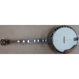 A five string banjo with a silver eagle emblem on the reverse,