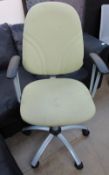 A green upholstered office elbow chair
