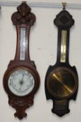 An oak cased aneroid barometer together with another oak cased barometer