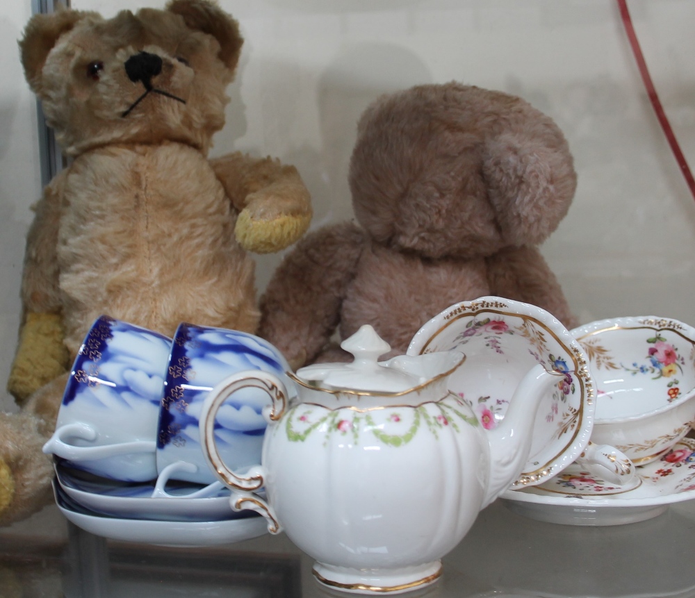 Two teddy bears together with tea cups and saucers etc