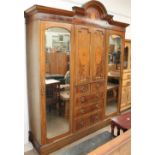 An Edwardian mahogany triple wardrobe together with a dressing table and bed