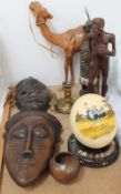 A painted ostrich egg on stand together with carved figures and mask and leather camel