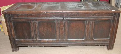 A large 18th century oak coffer with a four panelled top and front on stiles