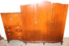 A 20th century mahogany triple wardrobe together with a matching dressing table and a tallboy