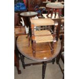 A 20th century oak gate leg dining table together with an oak stool, two rush seated stools,