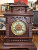 An early 20th century mantle clock with a circular dial and Roman numerals