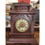 An early 20th century mantle clock with a circular dial and Roman numerals