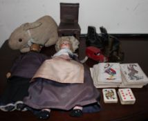 A Japanese souvenir doll together with another doll, a rabbit teddy bear, playing cards,