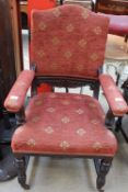 An Edwardian upholstered mahogany elbow chair on reeded legs and casters