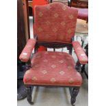 An Edwardian upholstered mahogany elbow chair on reeded legs and casters