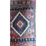 A room size red ground rug together with two smaller rugs