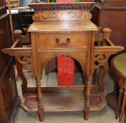 An early 20th century oak hall stand with a central drawer and wells