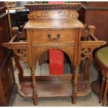 An early 20th century oak hall stand with a central drawer and wells