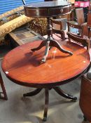 A large reproduction mahogany drum topped dining table together with a similar occasional table