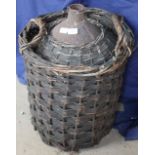 A wicker work basket containing a metal casket