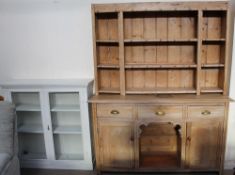 A pine kitchen dresser with a married shelved top, the base with drawers and cupboards,