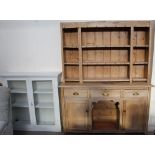 A pine kitchen dresser with a married shelved top, the base with drawers and cupboards,