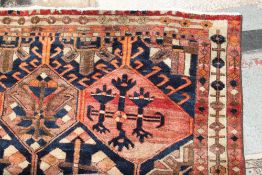 A Persian rug with a red ground and multiple medallions