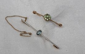 An aquamarine bar brooch set with an oval faceted aquamarine on a white metal setting and yellow