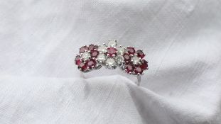 A ruby and diamond triple cluster ring the central cluster set with a single ruby,