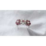 A ruby and diamond triple cluster ring the central cluster set with a single ruby,