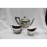 A late Victorian silver three piece teaset, of oval form with a part gadrooned body, Sheffield,