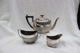 A late Victorian silver three piece teaset, of oval form with a part gadrooned body, Sheffield,