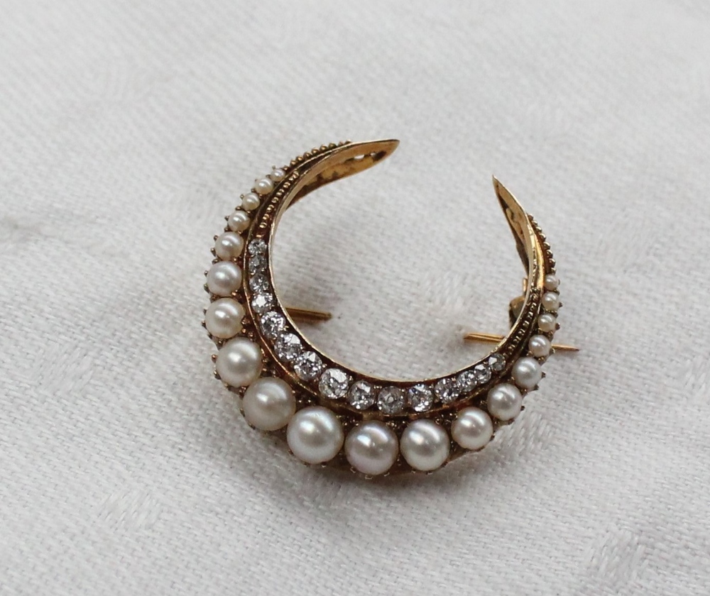 A diamond and pearl crescent brooch,