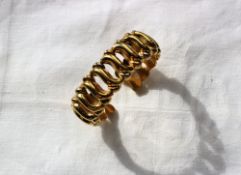 An 18ct yellow gold bangle with scrolling links,