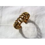 An 18ct yellow gold bangle with scrolling links,