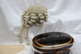 A Ravenscroft Law registrars wig contained within a black and gilt decorated oval tin,