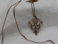 An Edwardian peridot and seed pearl pendant in a 9ct gold setting on a 9ct gold chain,
