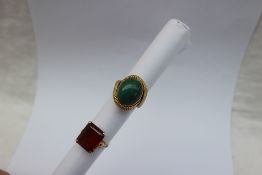 A yellow metal ring set with a cabochon hardstone, marked 750,