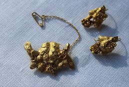 A yellow metal brooch in the form of grapes and leaves, together with a pair of matching earrings,