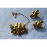 A yellow metal brooch in the form of grapes and leaves, together with a pair of matching earrings,