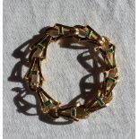 A yellow metal and emerald set bracelet,
