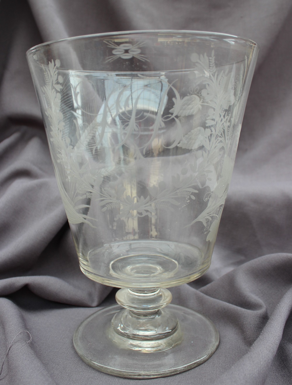 A 19th century oversize drinking glass, the flared bowl engraved with vine leaves and hops,