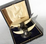 A pair of George V silver and ivory knife rests, in the form of horns on an oval base, loaded,