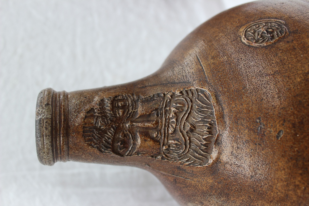 A large 18th century salt glazed Bellarmine mask jug, with a ring handle and finger marks, - Image 5 of 10