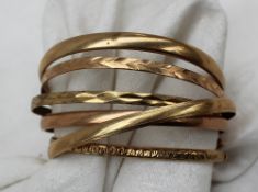 A collection of 9ct gold bangles, approximately 63.