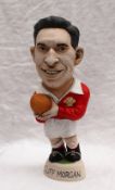 A resin Grogg of Cliff Morgan in red Wales jersey, holding a ball with No.