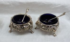 A pair of Victorian silver cauldron shaped salts embossed with roses and leaves on hoof feet, 1847,