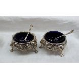 A pair of Victorian silver cauldron shaped salts embossed with roses and leaves on hoof feet, 1847,