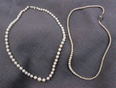 A pearl necklace set with sixty four individually knotted regular spherical pearls each