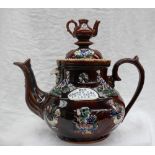 A late 19th century bargeware teapot, moulded with birds and vases of flowers,