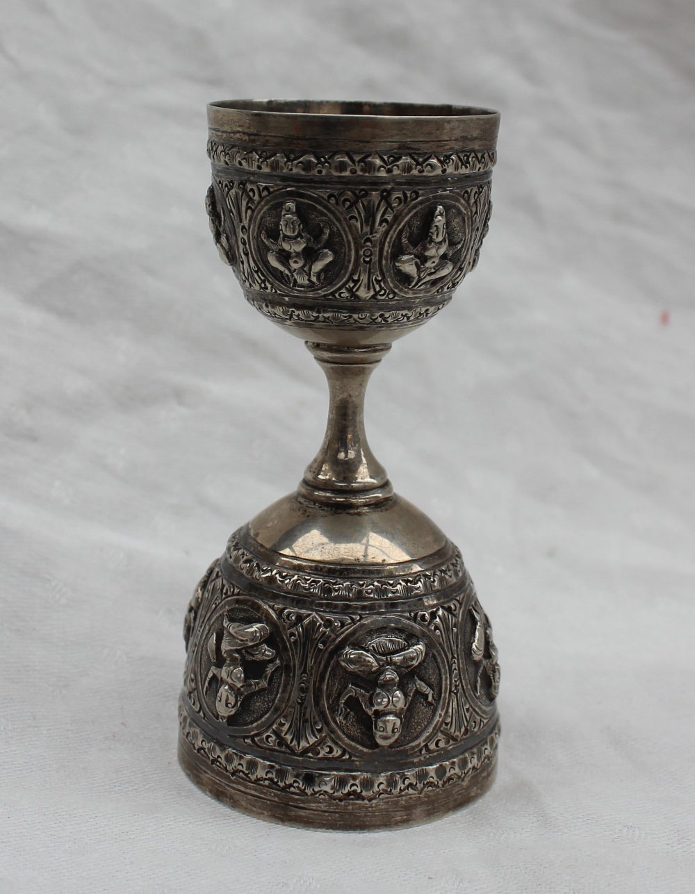 An Indian white metal double sided spirit measure, embossed with figures in roundels, 10cm high, - Bild 2 aus 4